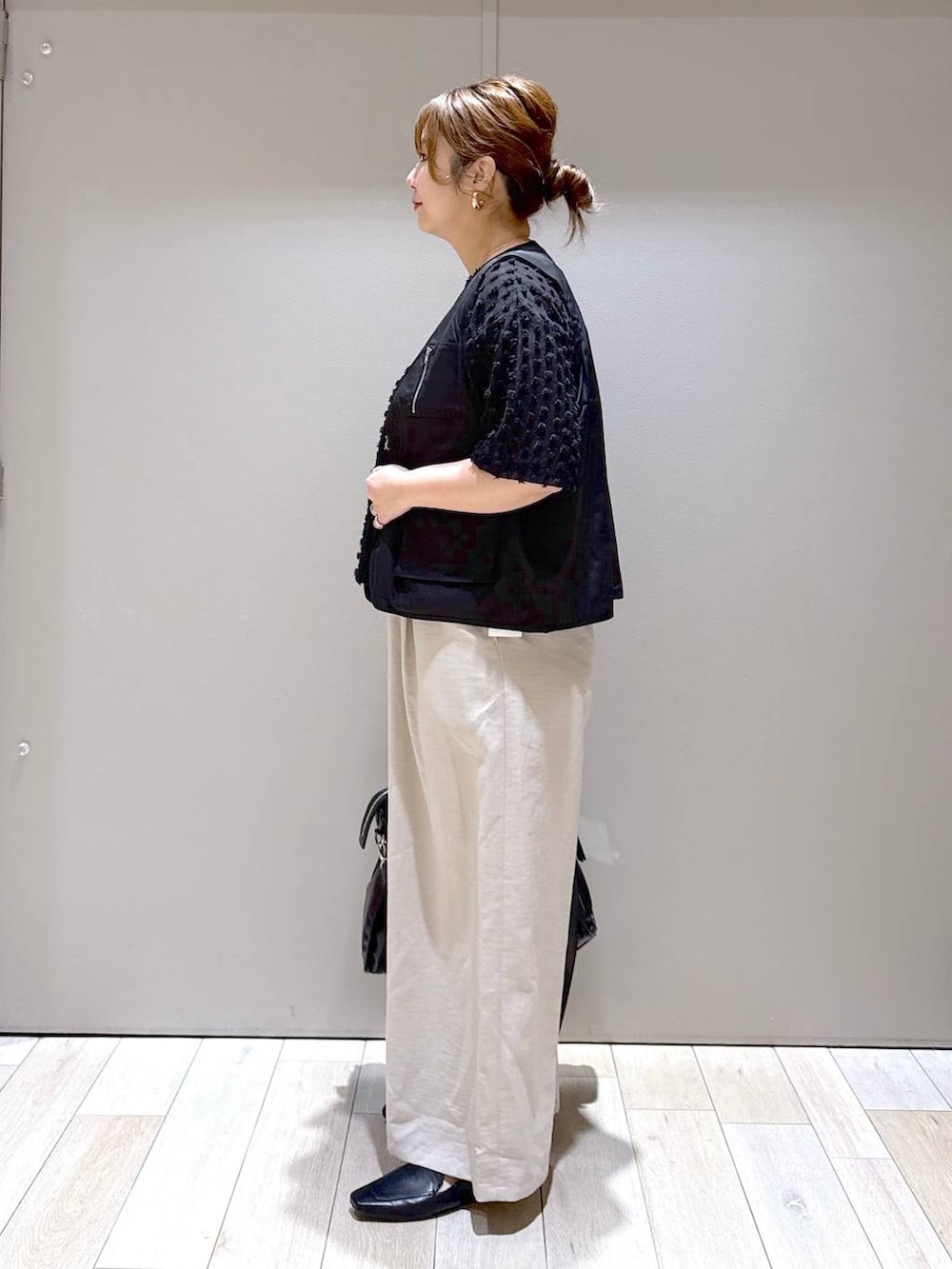 ブラック系のトートバッグ、ベージュ系のその他パンツ、ブラック系のローファーを着用したレディースの春コーディネートの4枚目の写真