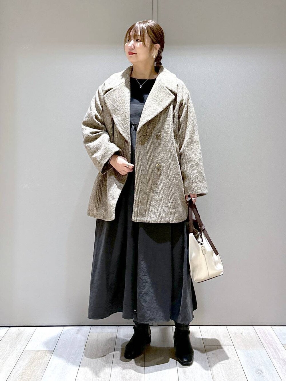ブラウン系のチェスターコート、ベージュ系のショルダーバッグ、ブラック系のブーツを着用したレディースの秋コーディネートの4枚目の写真