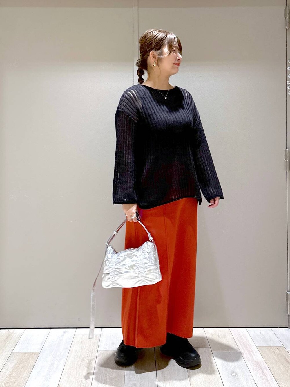 シルバー系のショルダーバッグ、ブラック系のニット/セーター、グレー系のタンクトップを着用したレディースの夏コーディネートの5枚目の写真