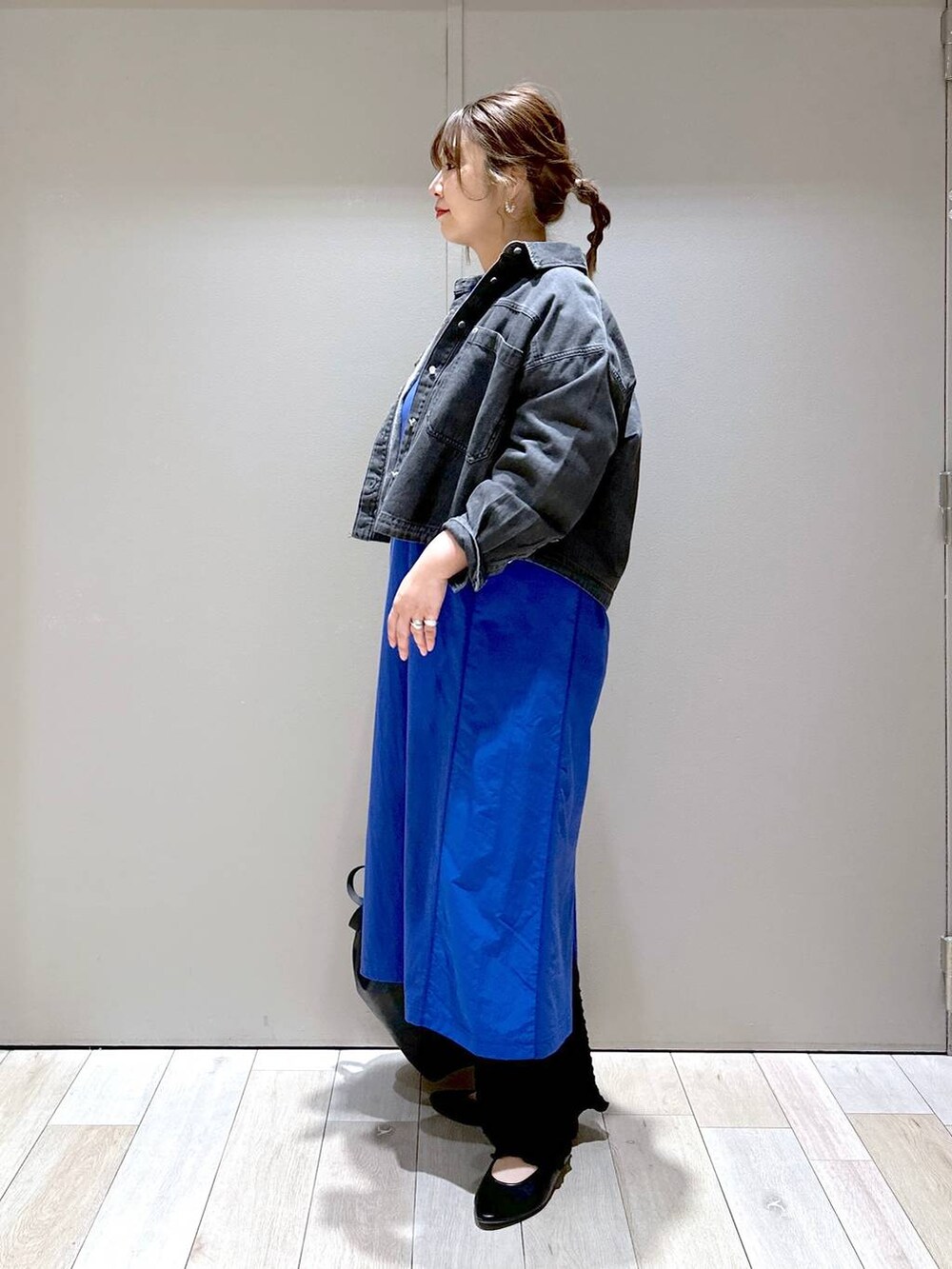 ブラック系のショルダーバッグ、ブルー系のワンピース、ブラック系のパンプスを着用したレディースの春コーディネートの4枚目の写真