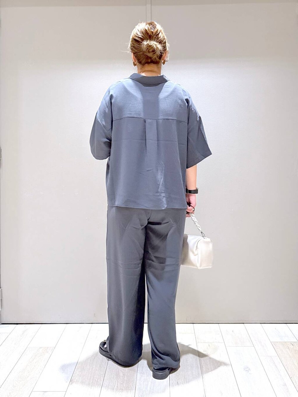 グレー系のその他パンツ、ブラック系のサンダル、ホワイト系のショルダーバッグを着用したレディースの夏コーディネートの3枚目の写真