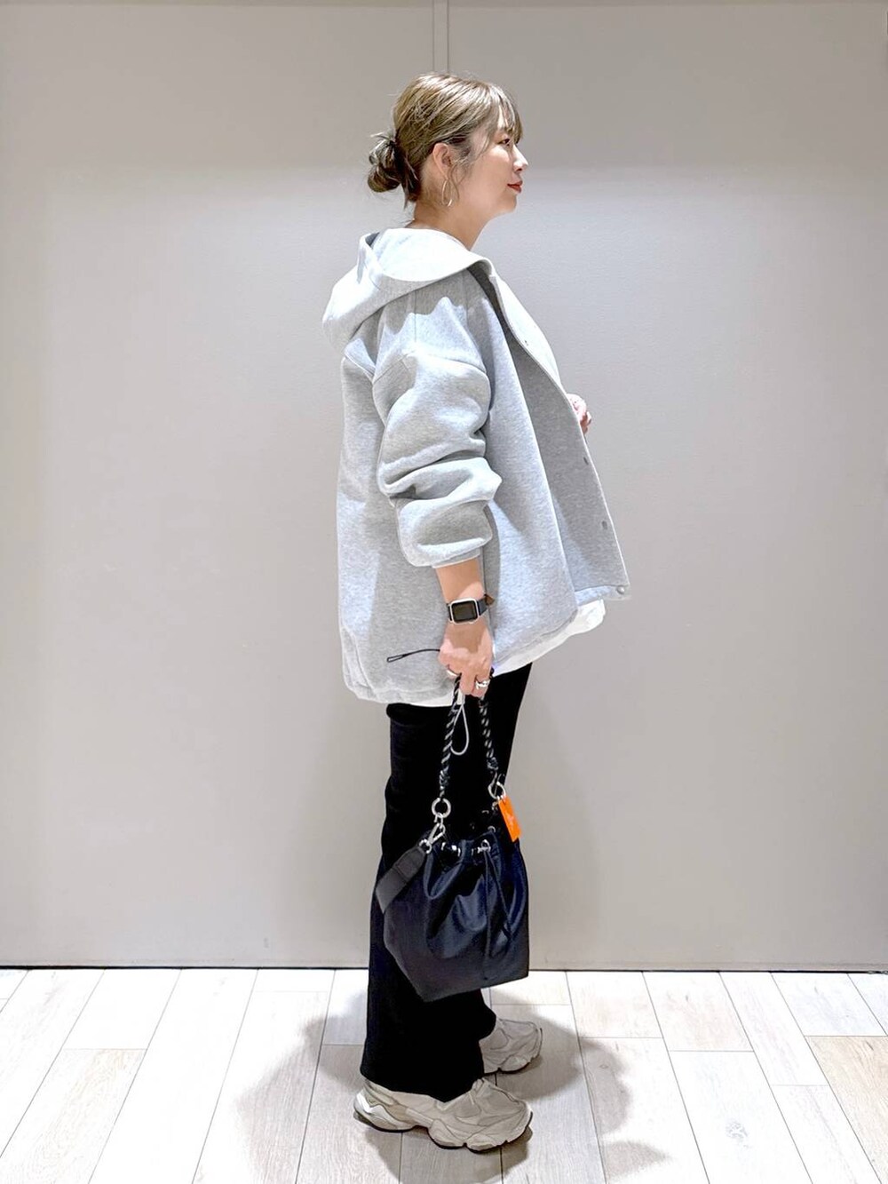 グレー系のブルゾン、ブラック系のショルダーバッグ、ホワイト系のTシャツ/カットソーを着用したレディースの秋コーディネートの2枚目の写真