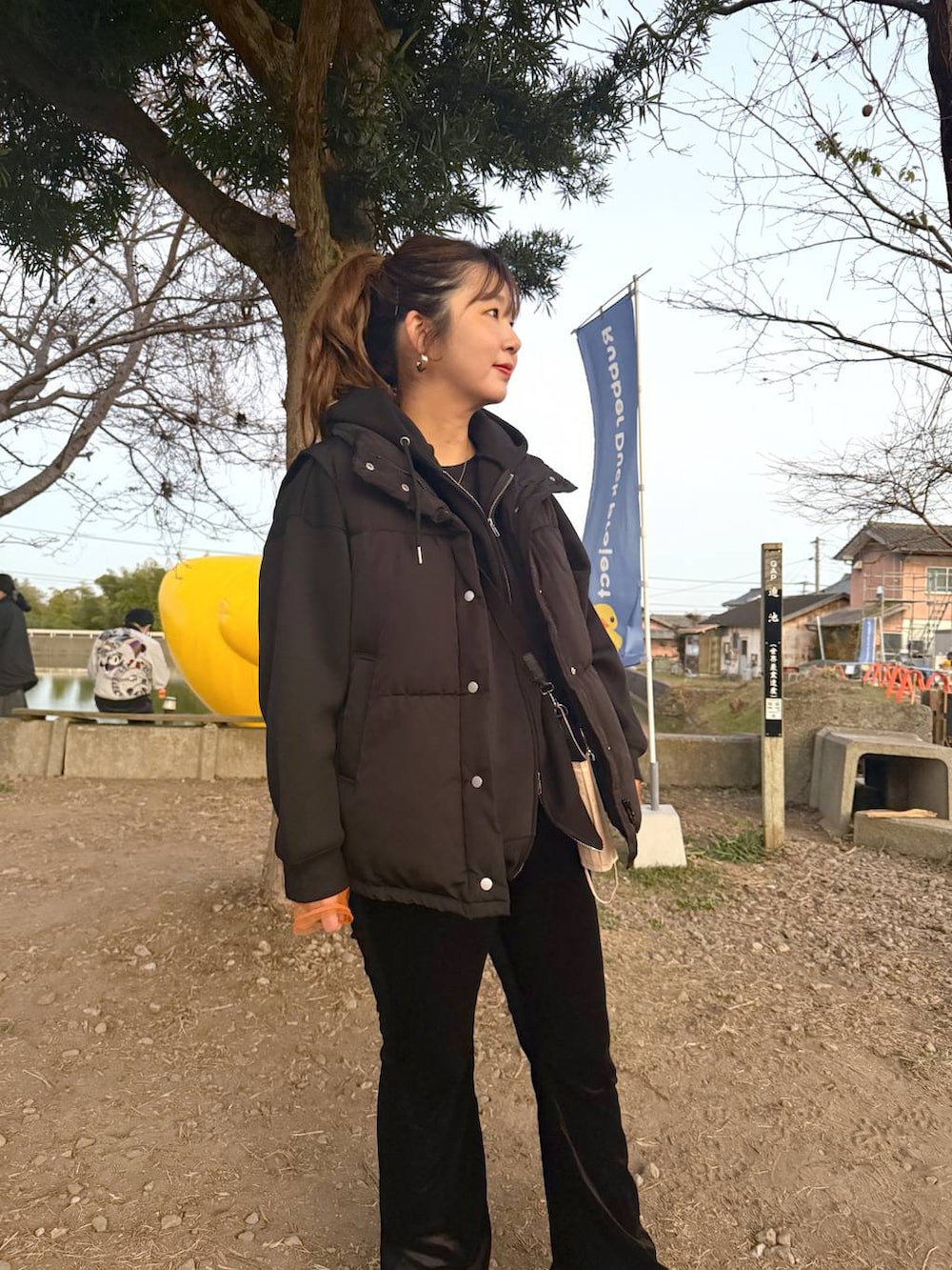 オレンジ系のTシャツ/カットソー、ブラック系のその他パンツ、ブラック系のパーカーを着用したレディースの冬コーディネートの2枚目の写真