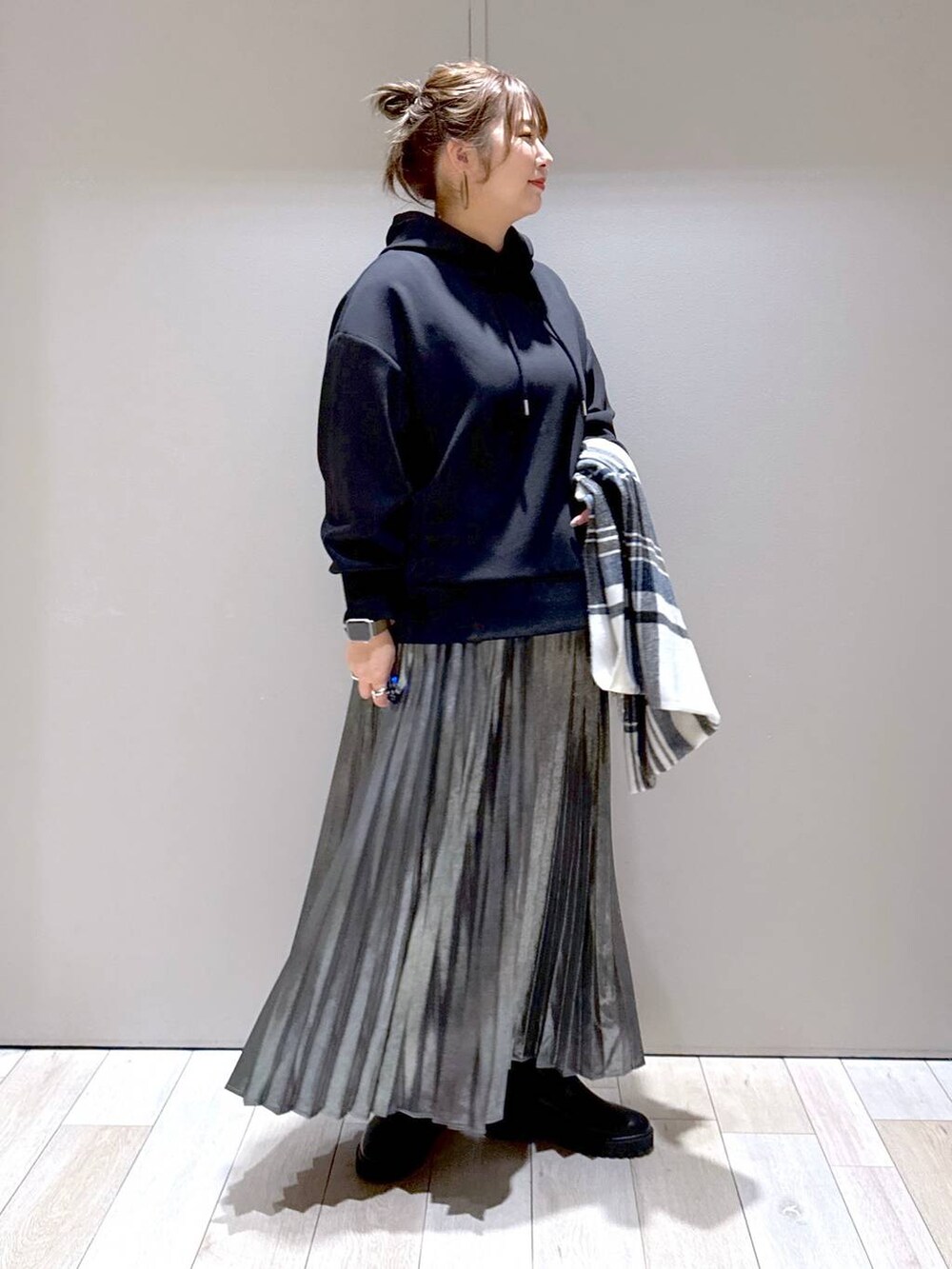 ブラック系のブーツ、ブラック系のパーカー、グレー系のスカートを着用したレディースの冬コーディネートの2枚目の写真