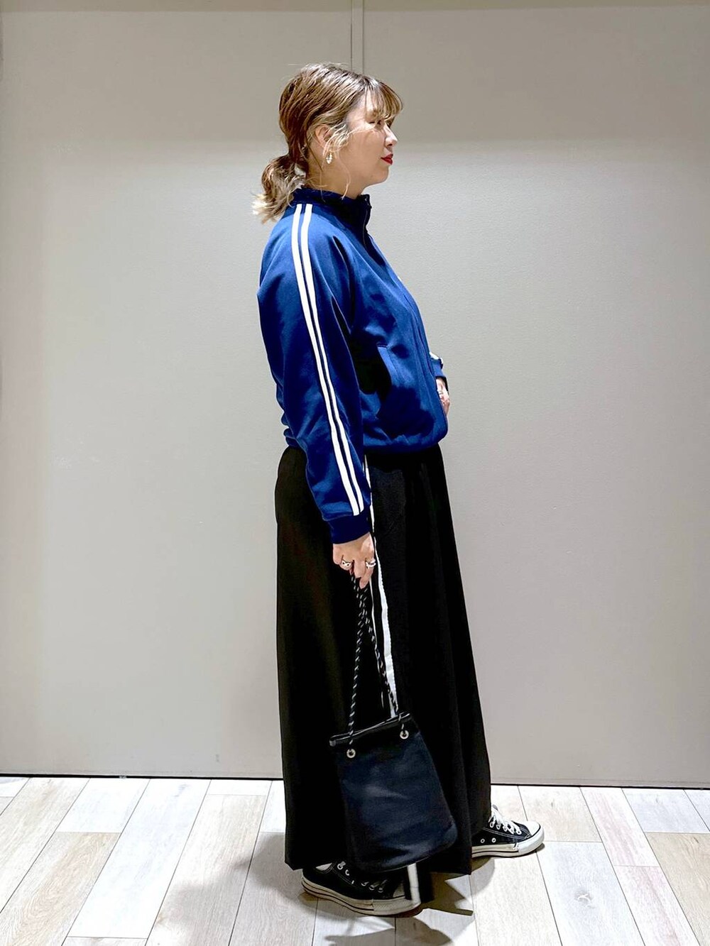 ブルー系のその他アウター、ブラック系のその他パンツ、ゴールド系のピアス(両耳用)を着用したレディースの秋コーディネートの2枚目の写真