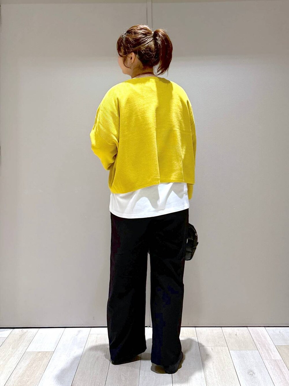 ブラック系のバレエシューズ、イエロー系のニット/セーター、ブラック系のボストンバッグを着用したレディースの秋コーディネートの3枚目の写真