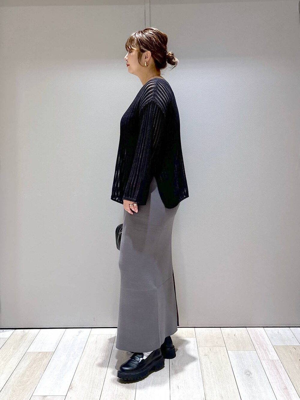 ブラック系のニット/セーター、ブラック系のボストンバッグ、ブラック系のローファーを着用したレディースの秋コーディネートの4枚目の写真