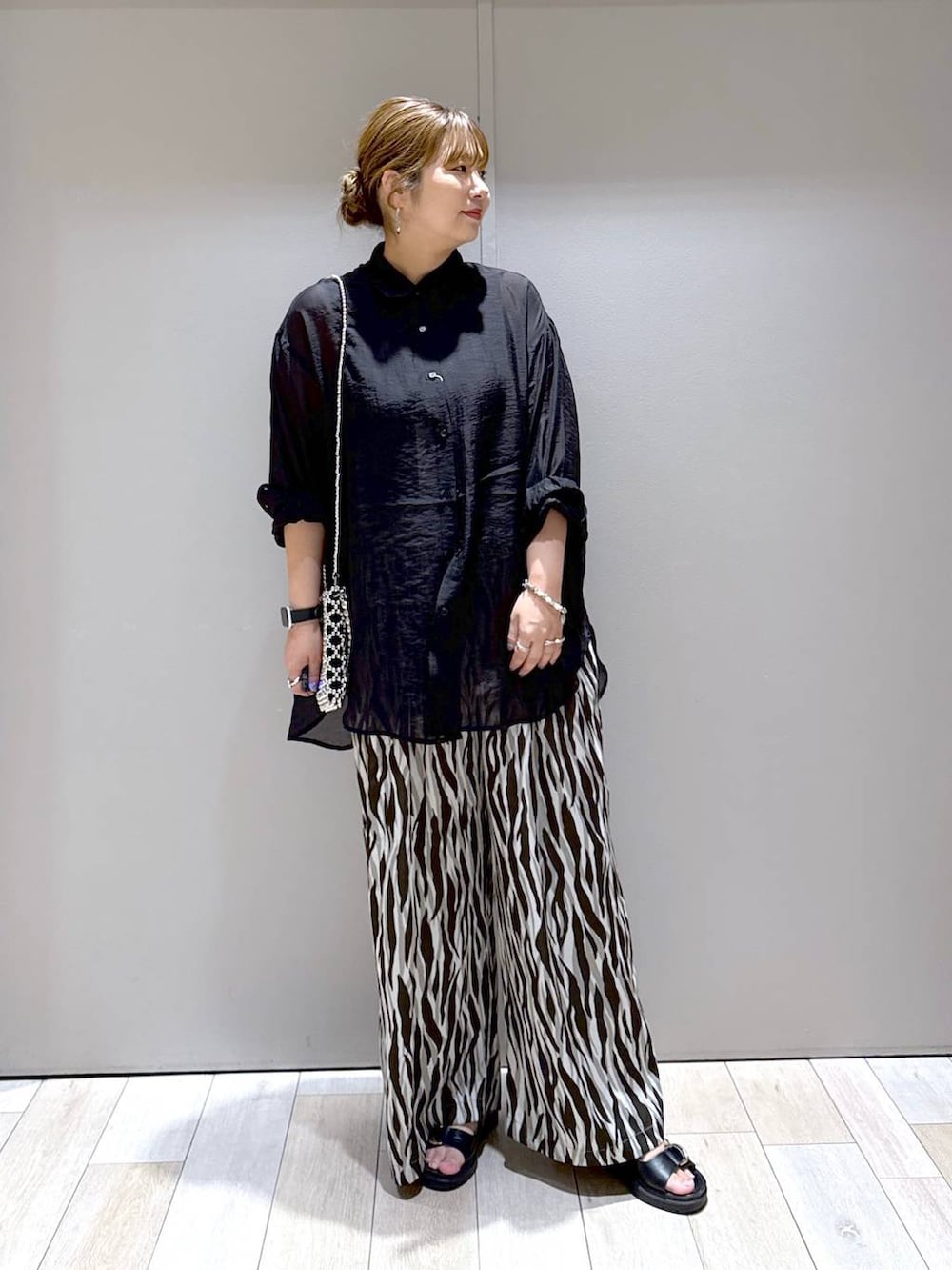 ブラック系のサンダル、シルバー系のショルダーバッグ、ブラック系のシャツ/ブラウスを着用したレディースの夏コーディネートの5枚目の写真