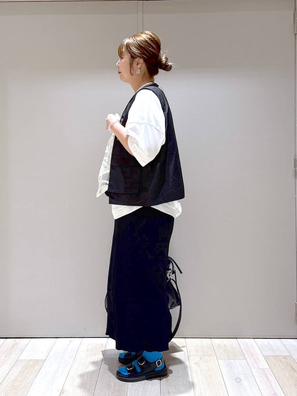 ブラック系のスカート、ブラック系のトートバッグ、ホワイト系のTシャツ/カットソーを着用したレディースの春コーディネートの4枚目の写真