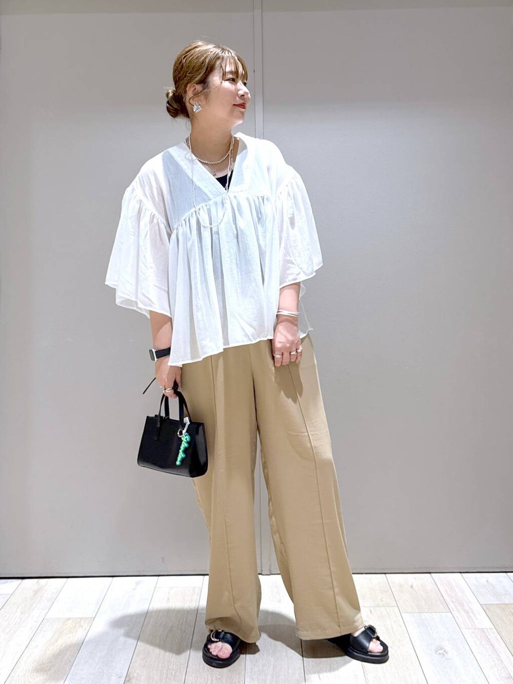 ベージュ系のその他パンツ、ホワイト系のシャツ/ブラウス、ブラック系のタンクトップを着用したレディースの春コーディネートの6枚目の写真