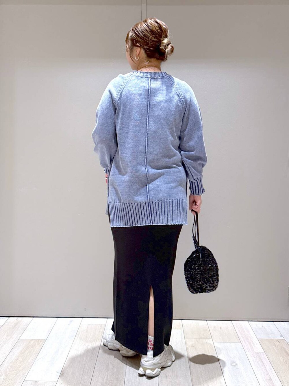 ブラック系のショルダーバッグ、ブラック系のスカート、ブルー系のニット/セーターを着用したレディースの冬コーディネートの3枚目の写真