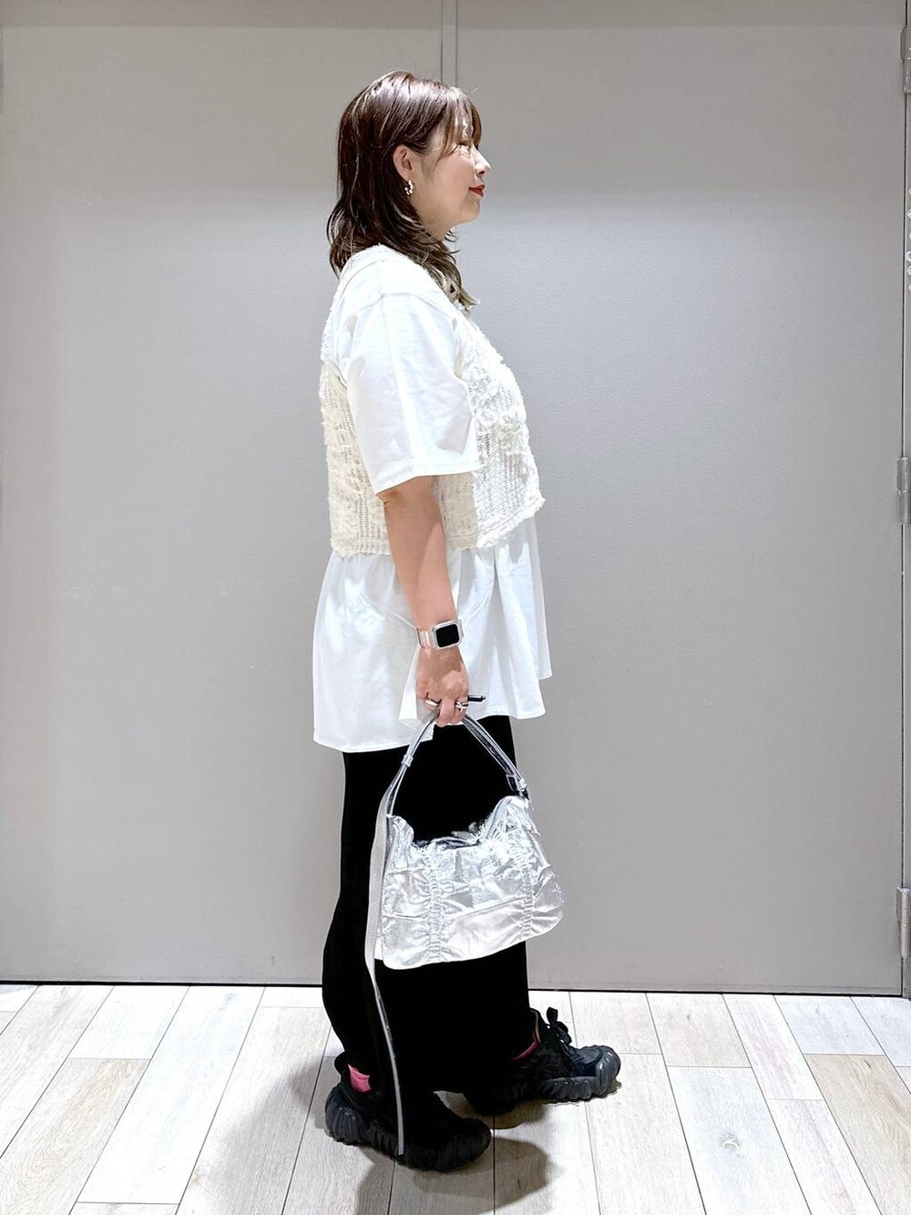 シルバー系のショルダーバッグ、ホワイト系のTシャツ/カットソー、ブラック系のスカートを着用したレディースの秋コーディネートの2枚目の写真