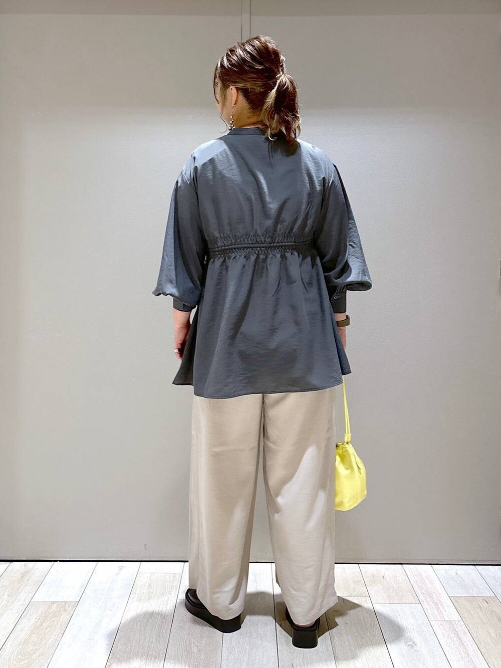 グレー系のシャツ/ブラウス、イエロー系のショルダーバッグ、ブラック系のサンダルを着用したレディースの春コーディネートの3枚目の写真