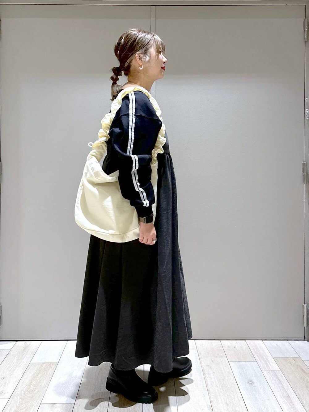 ブラック系のブーツ、ホワイト系のショルダーバッグ、ブラック系のTシャツ/カットソーを着用したレディースの秋コーディネートの2枚目の写真