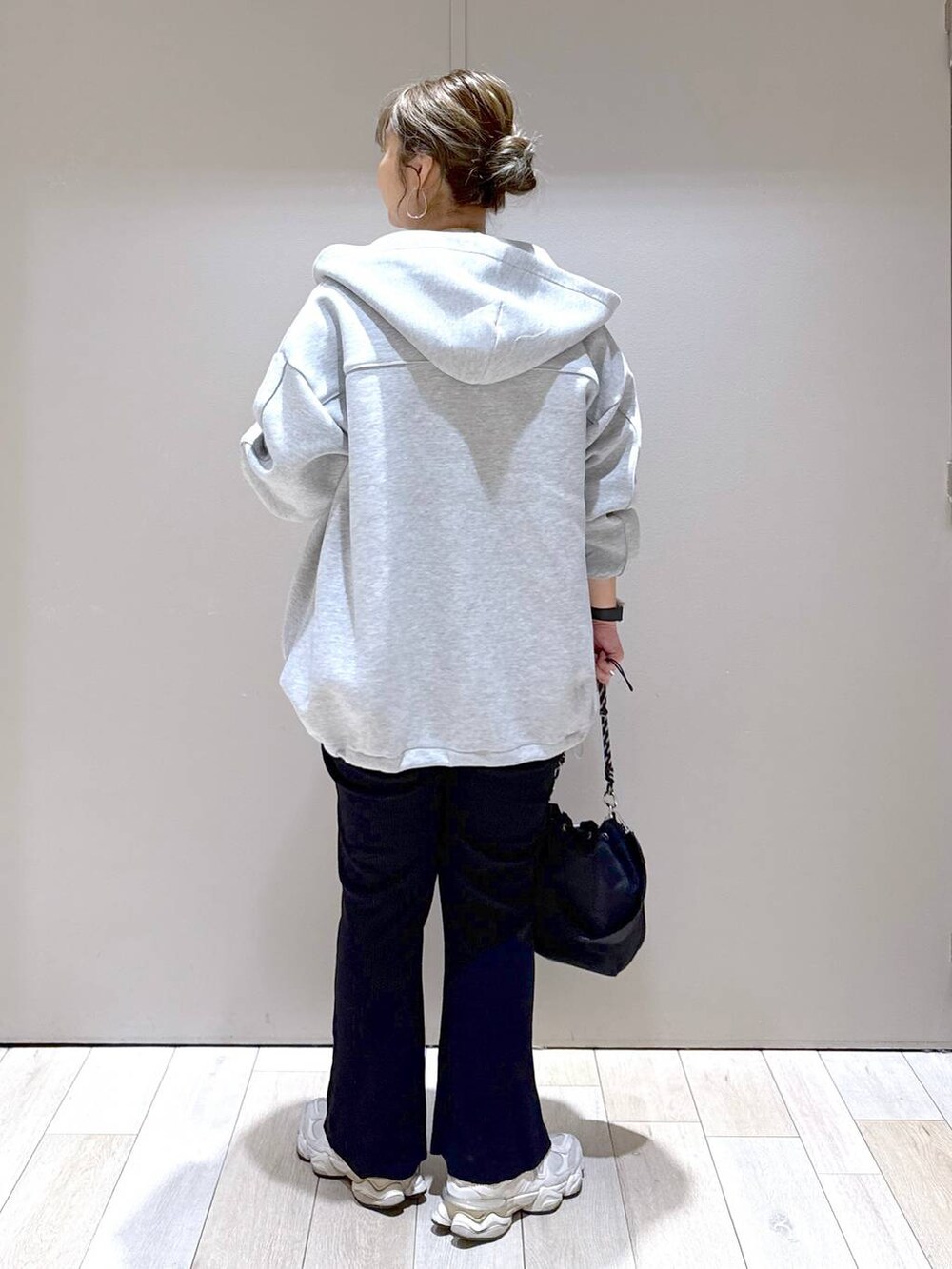 グレー系のブルゾン、ブラック系のショルダーバッグ、ホワイト系のTシャツ/カットソーを着用したレディースの秋コーディネートの3枚目の写真