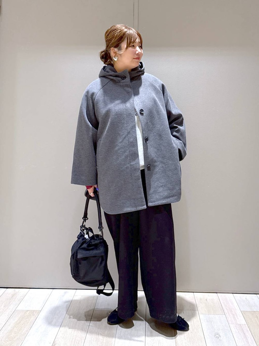 ブラック系のショルダーバッグ、グレー系のポンチョ、ブラック系のその他パンツを着用したレディースの冬コーディネートの5枚目の写真
