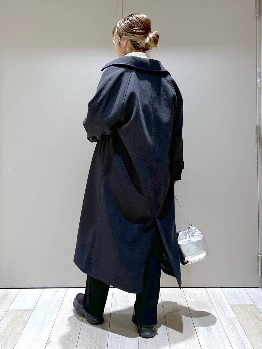 ブラック系のその他パンツ、グレー系のステンカラーコート、ホワイト系のニット/セーターを着用したレディースの冬コーディネートの4枚目の写真