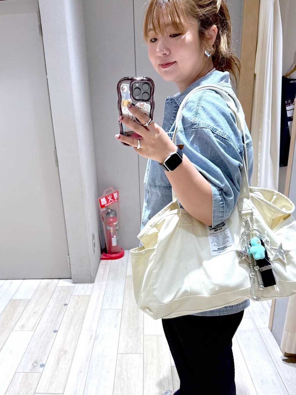 ブルー系のシャツ/ブラウス、シルバー系のキーホルダー、ブラック系のスマホグッズを着用したレディースの夏コーディネートの3枚目の写真