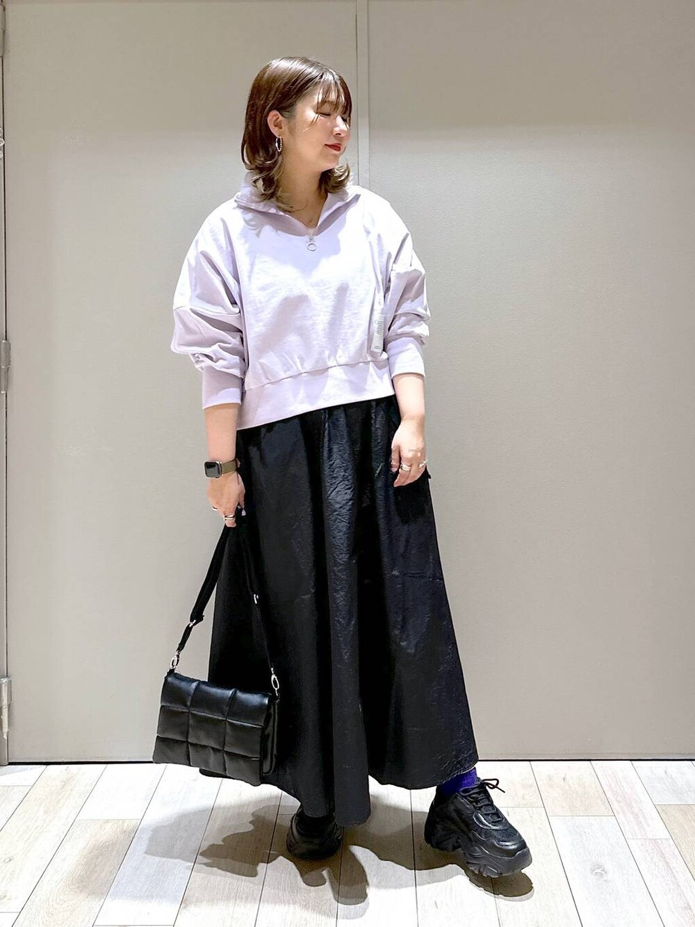 ブラック系のスニーカー、ブラック系のショルダーバッグ、ブラック系のスカートを着用したレディースの春コーディネートの5枚目の写真