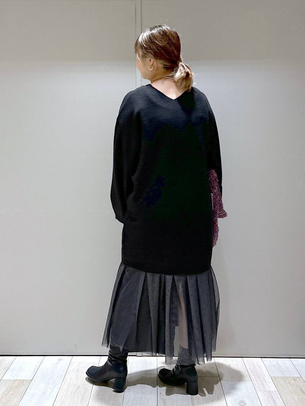 ブラック系のチュニック、ブラック系のブーツ、その他のショルダーバッグを着用したレディースの秋コーディネートの3枚目の写真