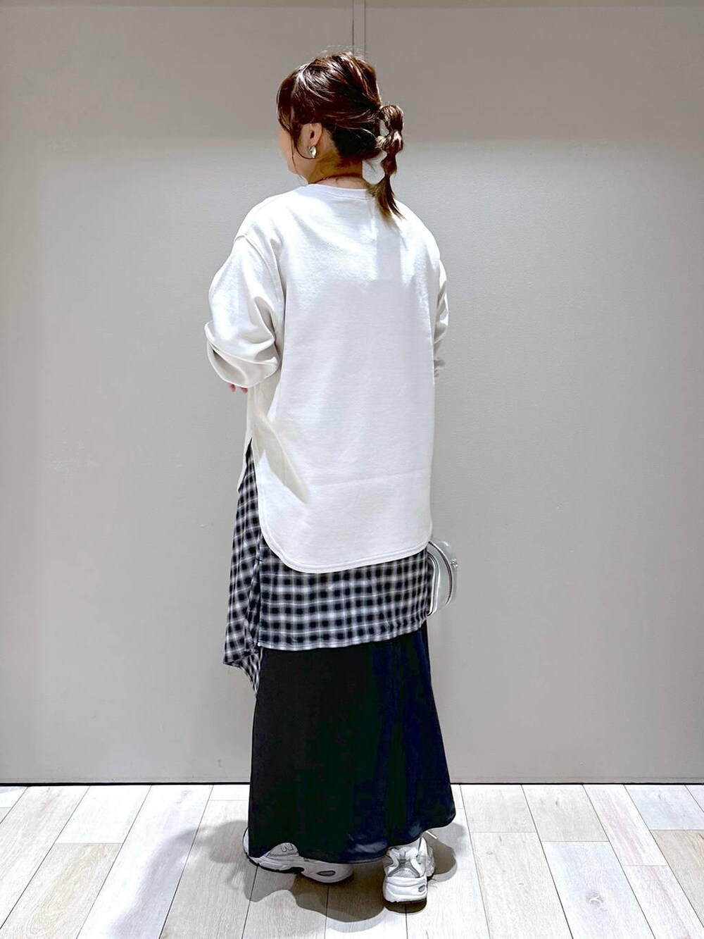 ベージュ系のTシャツ/カットソー、シルバー系のボストンバッグ、ブラック系のスカートを着用したレディースの秋コーディネートの4枚目の写真