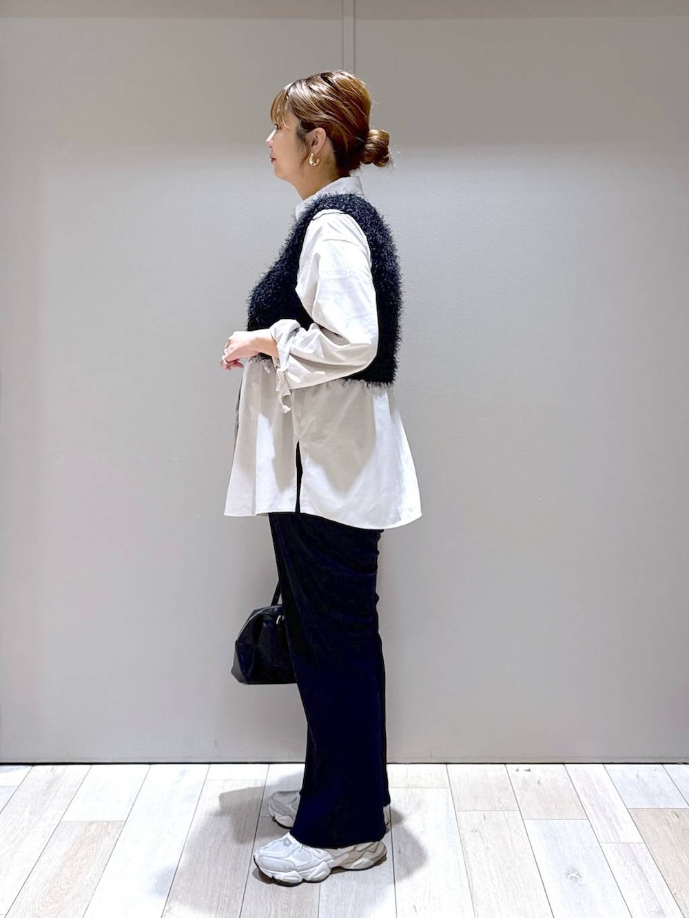 ベージュ系のシャツ/ブラウス、ブラック系のベスト、ブラック系のボストンバッグを着用したレディースの秋コーディネートの4枚目の写真