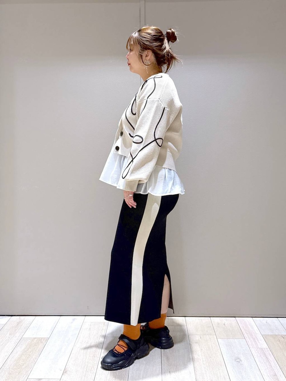 ホワイト系のTシャツ/カットソー、ブラック系のスニーカー、ブラック系のスカートを着用したレディースの春コーディネートの4枚目の写真