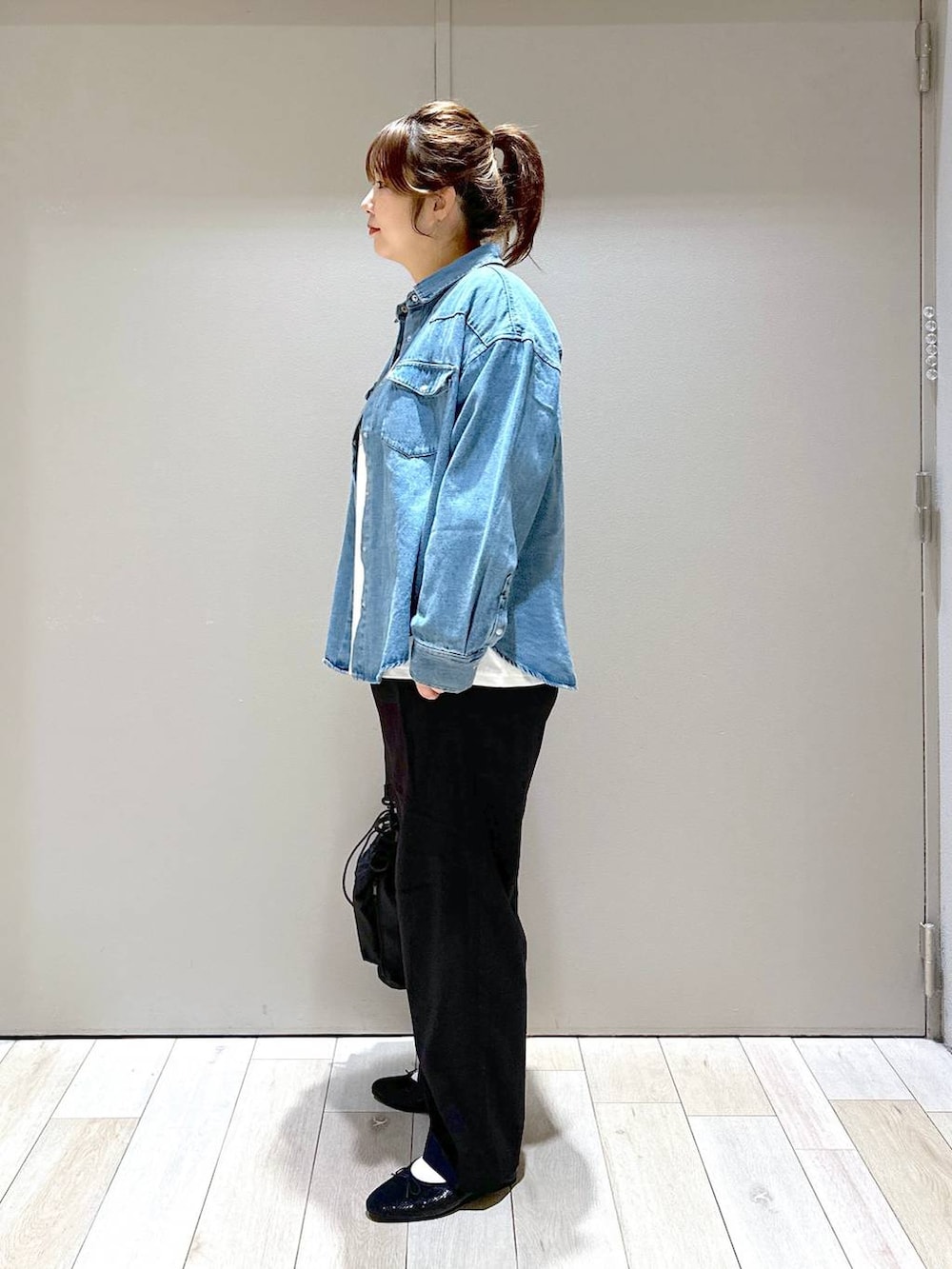 ブラック系のショルダーバッグ、ブラック系のバレエシューズ、ブルー系のシャツ/ブラウスを着用したレディースの秋コーディネートの4枚目の写真