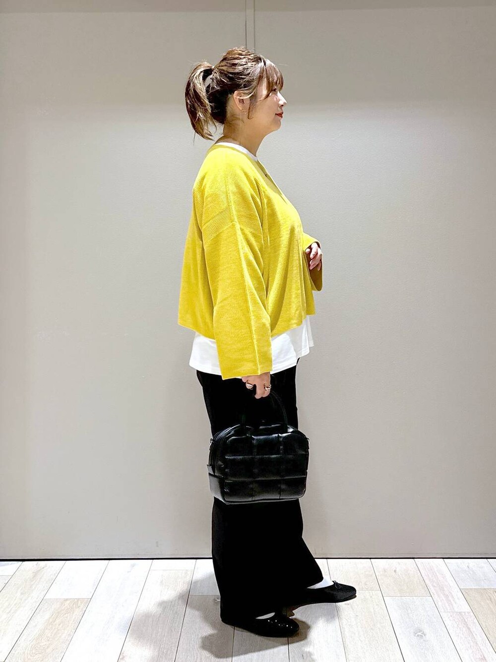 ブラック系のバレエシューズ、イエロー系のニット/セーター、ブラック系のボストンバッグを着用したレディースの秋コーディネートの2枚目の写真