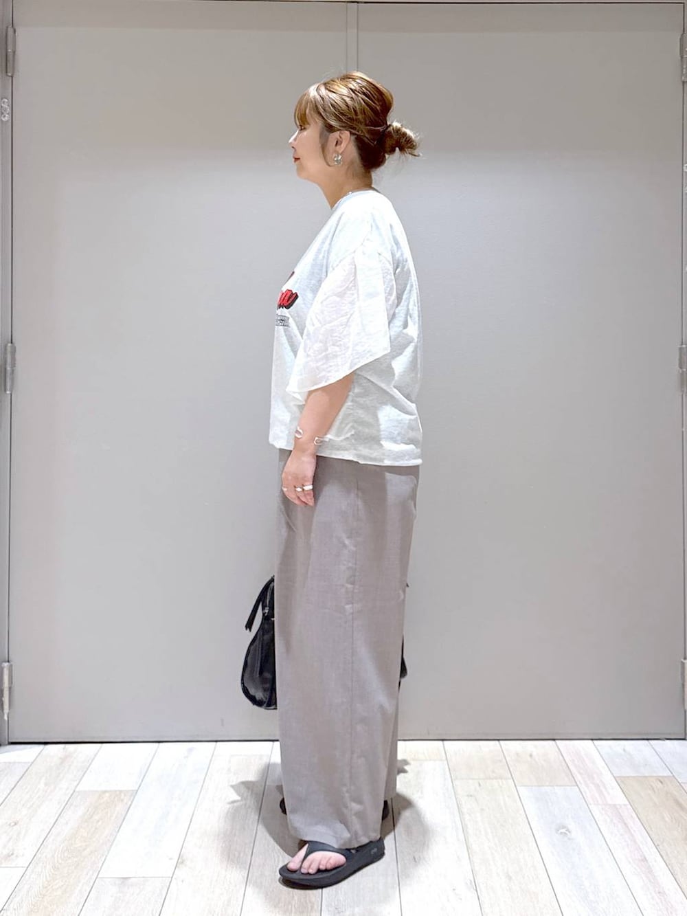 ブラック系のトートバッグ、ベージュ系のその他パンツ、ブラック系のサンダルを着用したレディースの春コーディネートの4枚目の写真
