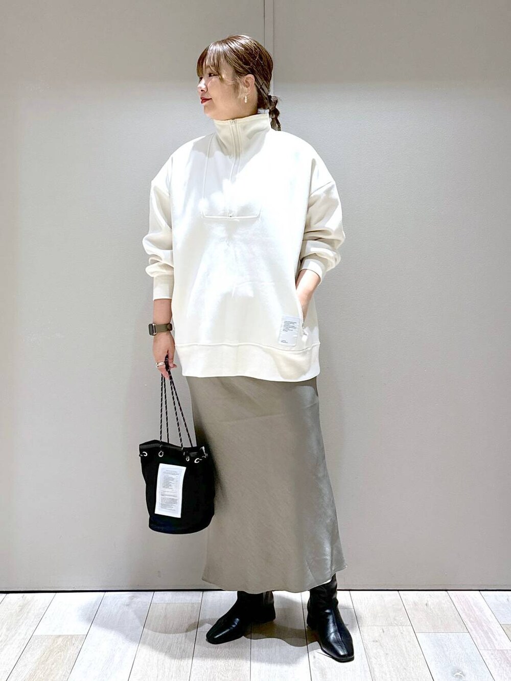 ホワイト系のTシャツ/カットソー、ブラック系のブーツ、グリーン系のスカートを着用したレディースの秋コーディネートの4枚目の写真