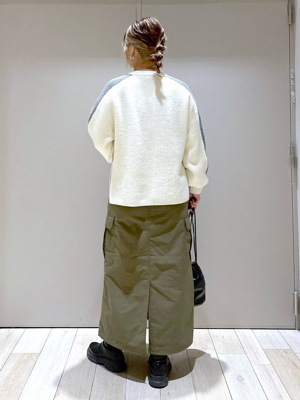 ホワイト系のニット/セーター、グリーン系のスカート、ブラック系のブーツを着用したレディースの冬コーディネートの4枚目の写真