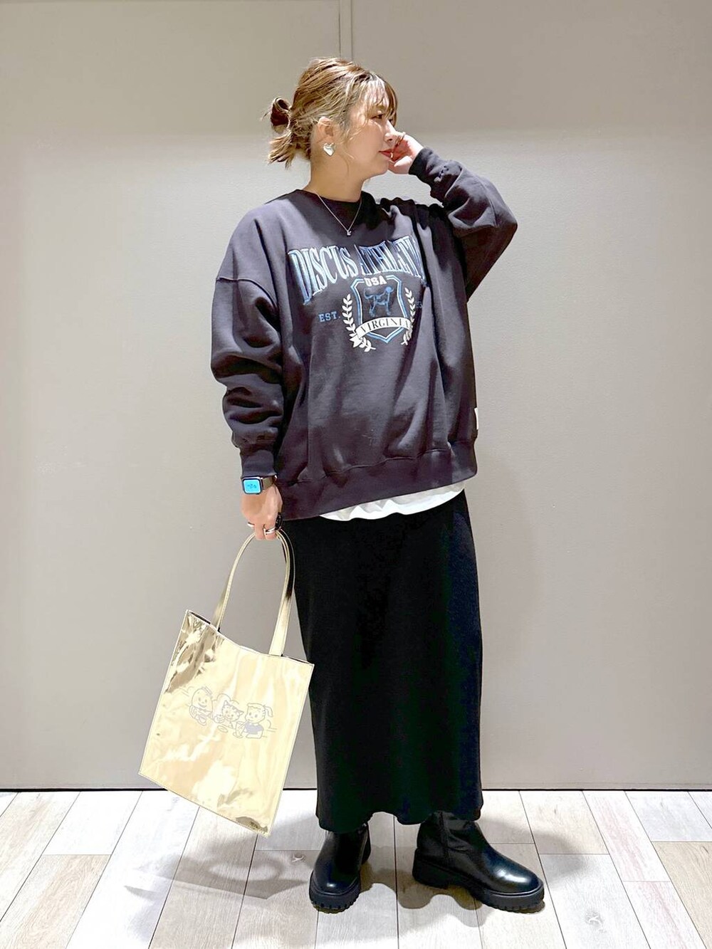 ブラック系のスカート、グレー系のスウェット、ブラック系のブーツを着用したレディースの冬コーディネートの4枚目の写真