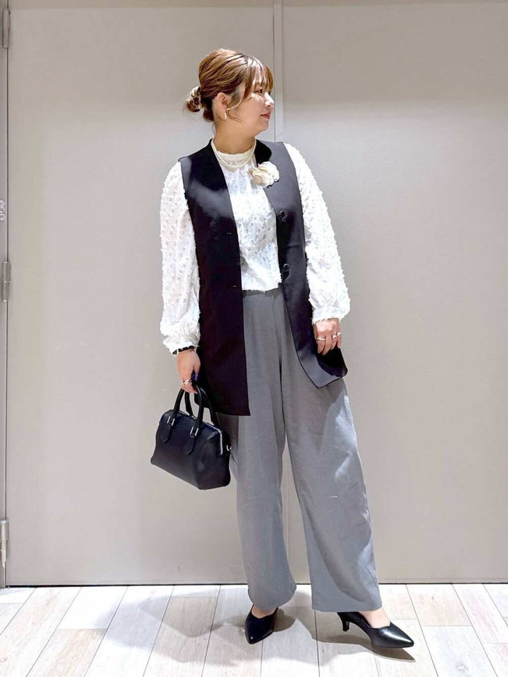 ホワイト系のシャツ/ブラウス、ブラック系のスーツベスト、グレー系のその他パンツを着用したレディースの冬コーディネートの5枚目の写真