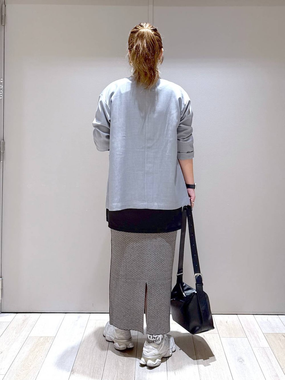 ブラック系のスカート、グレー系のテーラードジャケット、ブラック系のショルダーバッグを着用したレディースの秋コーディネートの3枚目の写真