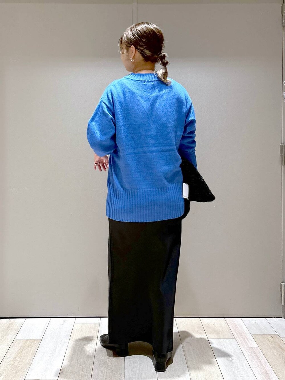 ブラック系のブーツ、ブラック系のショルダーバッグ、ブラック系のスカートを着用したレディースの秋コーディネートの3枚目の写真