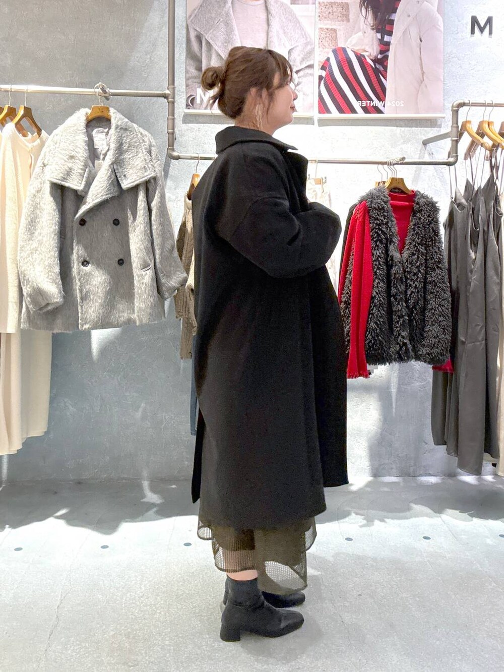 ブラック系のその他アウター、ブラック系のブーツ、グリーン系のドレスを着用したレディースの秋コーディネートの2枚目の写真