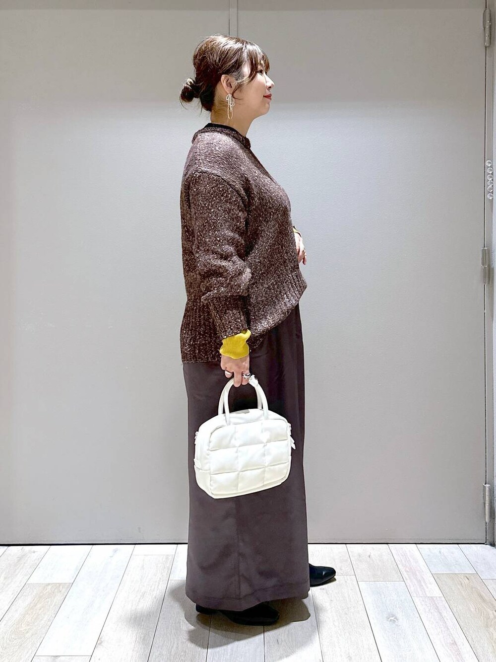 ブラック系のニット/セーター、グレー系のその他パンツ、ホワイト系のボストンバッグを着用したレディースの秋コーディネートの2枚目の写真