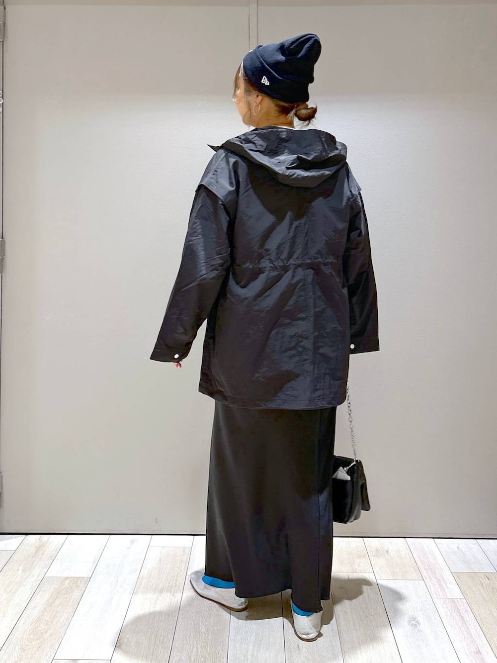 グレー系のチュニック、グレー系のパンプス、ブラック系のスカートを着用したレディースの春コーディネートの3枚目の写真