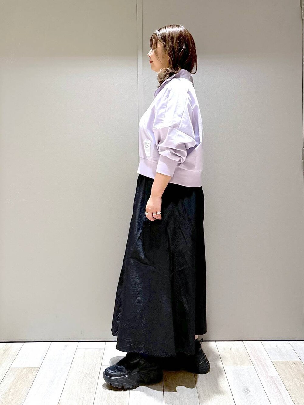 ブラック系のスニーカー、ブラック系のショルダーバッグ、ブラック系のスカートを着用したレディースの春コーディネートの4枚目の写真