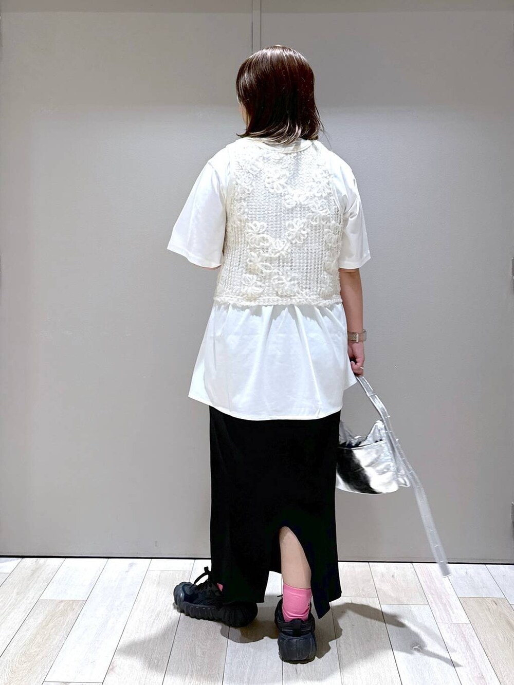 シルバー系のショルダーバッグ、ホワイト系のTシャツ/カットソー、ブラック系のスカートを着用したレディースの秋コーディネートの3枚目の写真