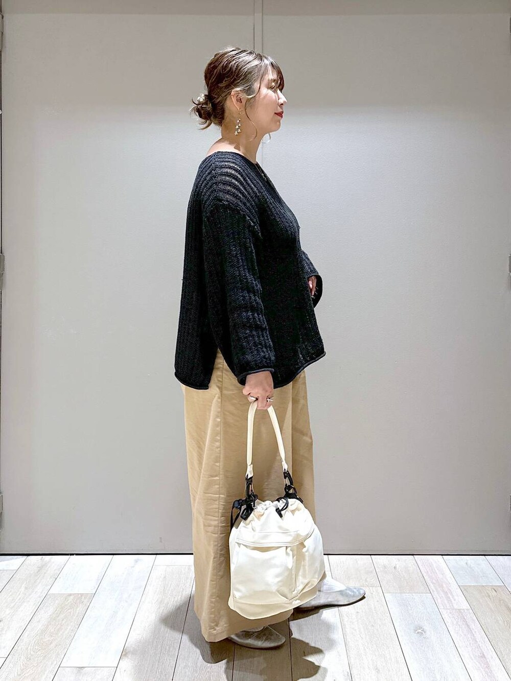 グレー系のパンプス、ホワイト系のショルダーバッグ、ベージュ系のチノパンツを着用したレディースの春コーディネートの2枚目の写真