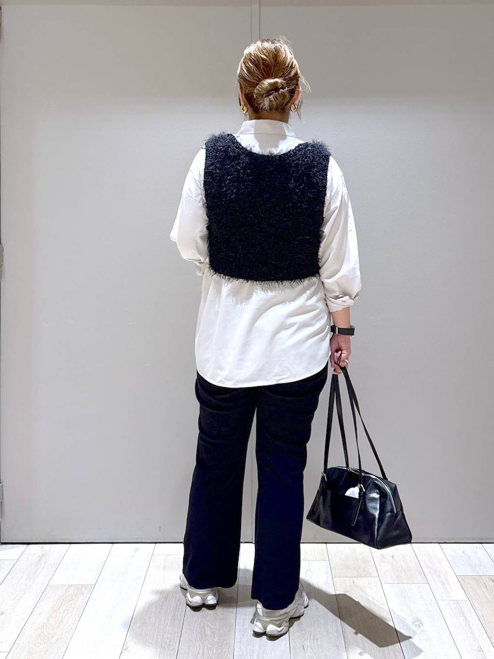 ベージュ系のシャツ/ブラウス、ブラック系のベスト、ブラック系のボストンバッグを着用したレディースの秋コーディネートの3枚目の写真