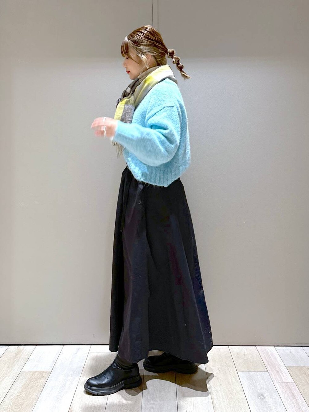 ブラック系のショルダーバッグ、ブラック系のブーツ、ブラック系のスカートを着用したレディースの冬コーディネートの6枚目の写真