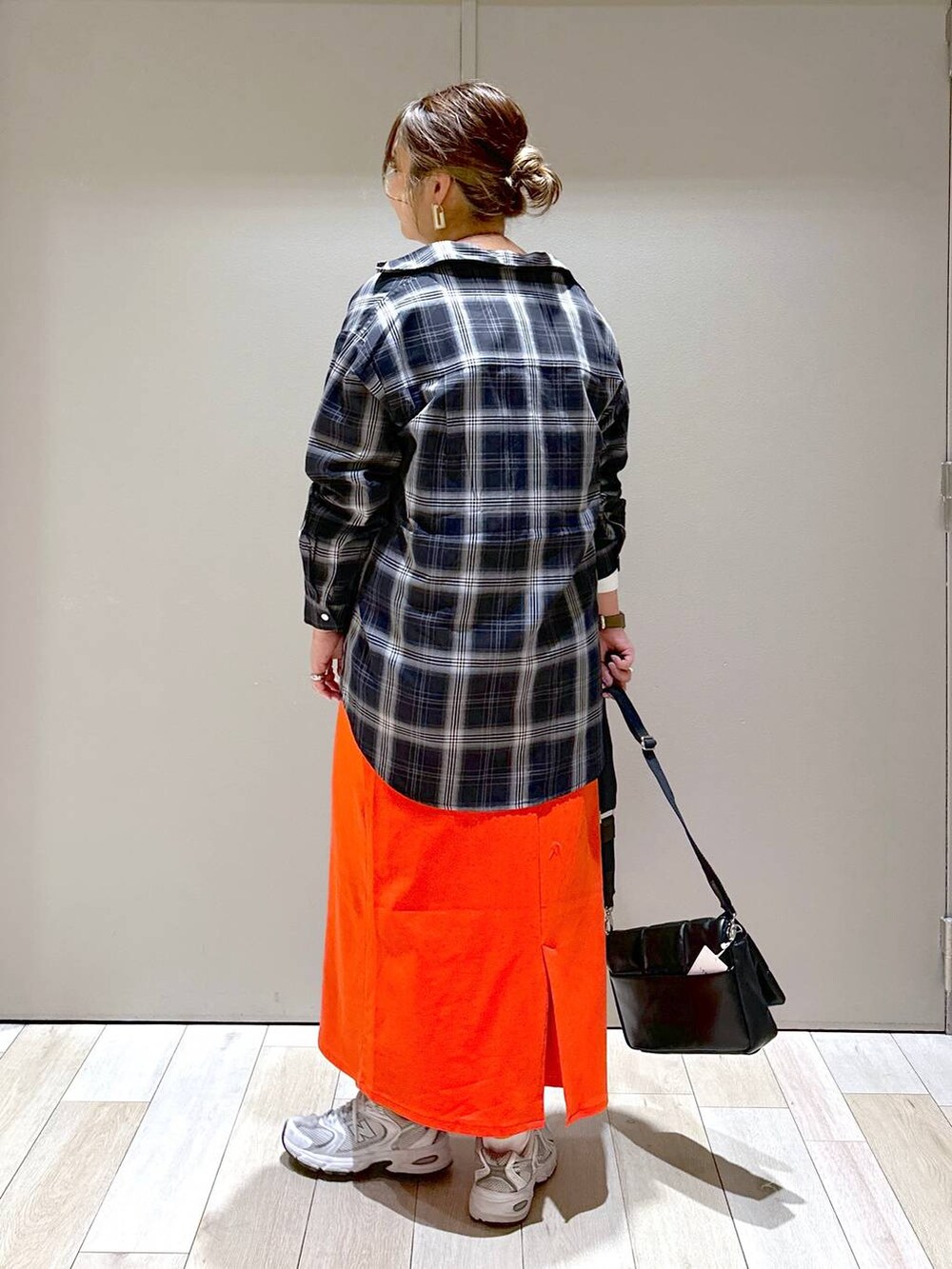 ブラック系のショルダーバッグ、ブラック系のシャツ/ブラウス、レッド系のスカートを着用したレディースの春コーディネートの3枚目の写真