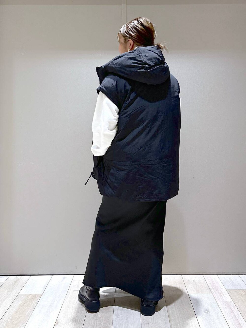 ブラック系のその他アウター、ブラック系のブーツ、ブラック系のショルダーバッグを着用したレディースの秋コーディネートの3枚目の写真