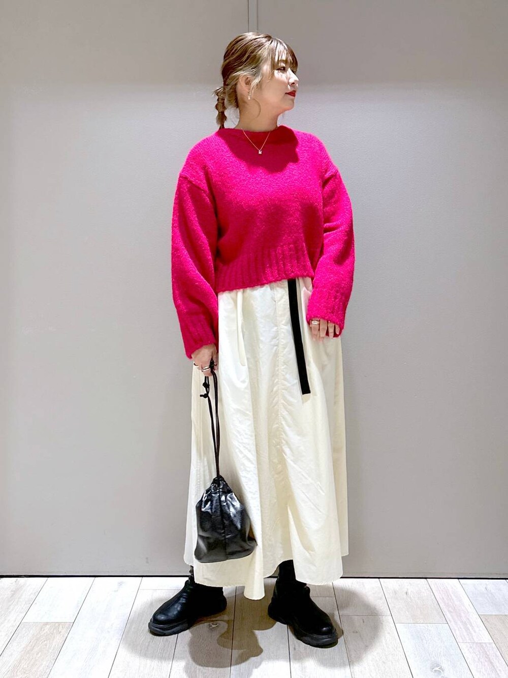 ブラック系のショルダーバッグ、ブラック系のブーツ、ホワイト系のスカートを着用したレディースの冬コーディネートの4枚目の写真