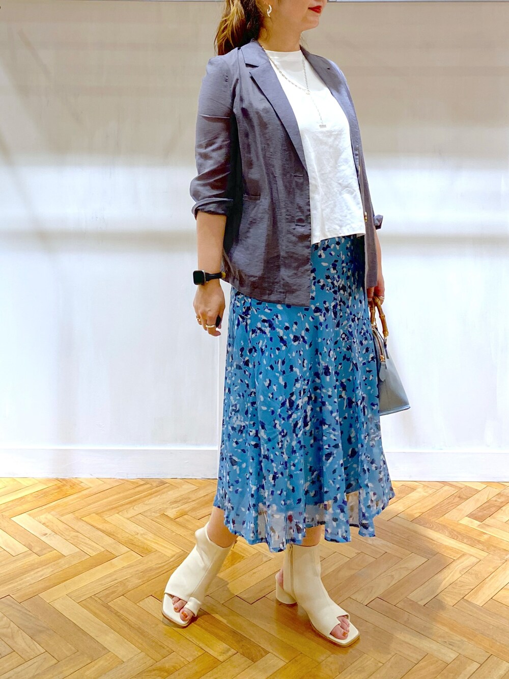 ホワイト系のTシャツ/カットソー、グレー系のテーラードジャケット、ブルー系のスカートを着用したレディースの夏コーディネートの2枚目の写真