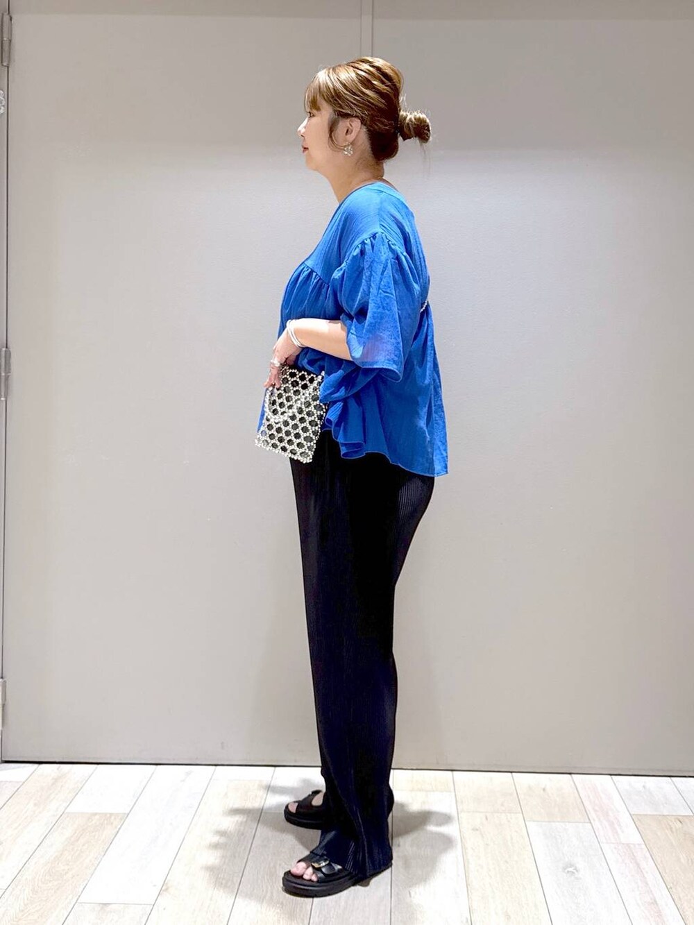 ブルー系のシャツ/ブラウス、ブラック系のTシャツ/カットソー、ブラック系のサンダルを着用したレディースの春コーディネートの4枚目の写真