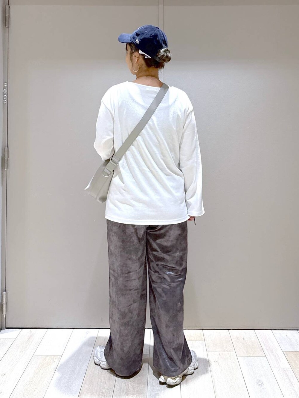グレー系のショルダーバッグ、グレー系のその他パンツ、ホワイト系のTシャツ/カットソーを着用したレディースの秋コーディネートの3枚目の写真